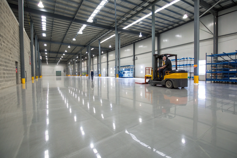 Industrial epoxy flooring in Toowoomba warehouse with forklift on high-gloss gray floor surface